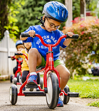 Boy with helmet riding on a tricycle