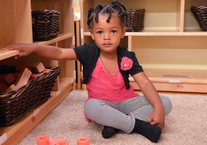 Young child sitting with her legs crossed