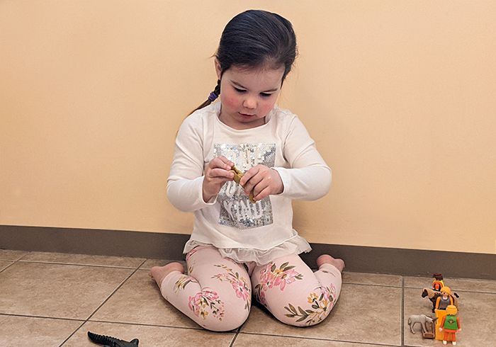 A young child w-sitting on the floor