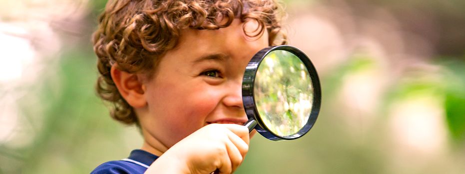 A young child looking through a magnifying glass