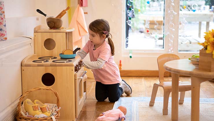 Girl playing with play collection stove