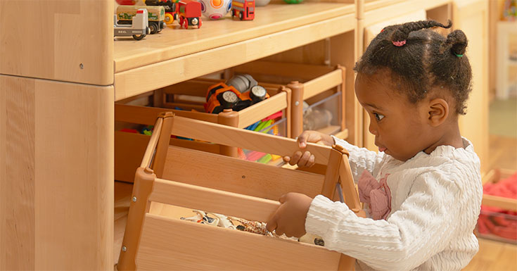 Child putting a carry crate on a shelf