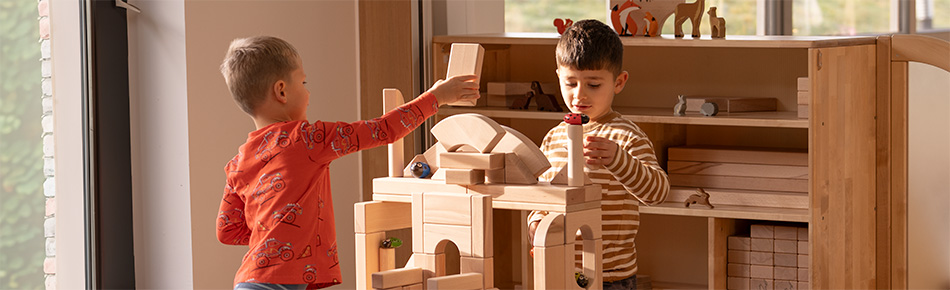 Two boys playing with wooden building blocks